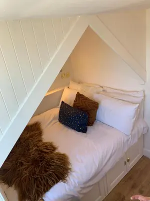 a white bed with a pile of pillows on it at This must be the place - Arran, Lamlash in Lamlash