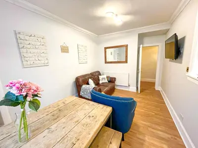 a living room with a wooden table and a couch at Rose Street's Hidden Treasure- 2Bed Newly Refurbished Apt in Edinburgh
