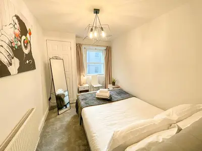 a bedroom with a bed and a painting on the wall at Rose Street's Hidden Treasure- 2Bed Newly Refurbished Apt in Edinburgh