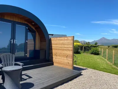 a wooden deck with a chair on a house at Raven's Gully - Brodick, Isle Of Arran in Brodick