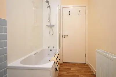 a white bath tub in a bathroom with a shower at Pedals and Paddles in Innellan