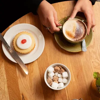 a person holding a cup of coffee and a plate of food at Brig o' Doon House Hotel in Ayr
