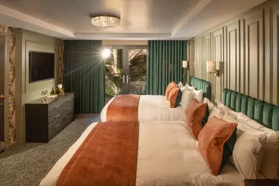 a hotel room with two beds and a television at Brig o' Doon House Hotel in Ayr