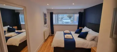 a small room with two beds and a window at Laighdykes Guest Cottage in Saltcoats