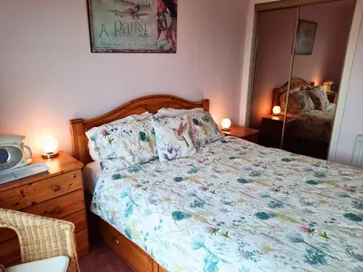 a bedroom with a bed with a floral bedspread at Links Quay 42 in Prestwick