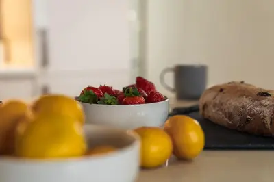 a bowl of strawberries and other fruit on a counter at The Penthouse Suite - Luxury Like No Other in Glasgow