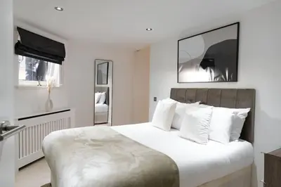 a white bedroom with a large bed with white pillows at The Penthouse Suite - Luxury Like No Other in Glasgow