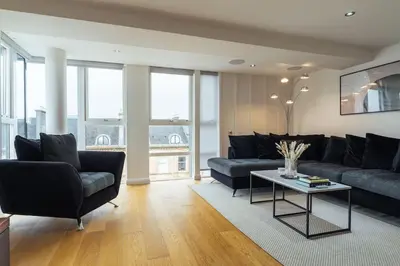 a living room with two couches and a table at The Penthouse Suite - Luxury Like No Other in Glasgow