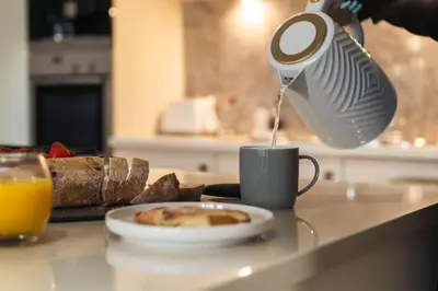 a person pouring coffee into a cup with a plate of food at The Penthouse Suite - Luxury Like No Other in Glasgow
