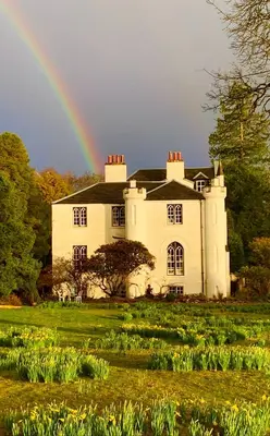 a rainbow in front of a large house with at Linnhe Apartment, Kinlochlaich House in Appin