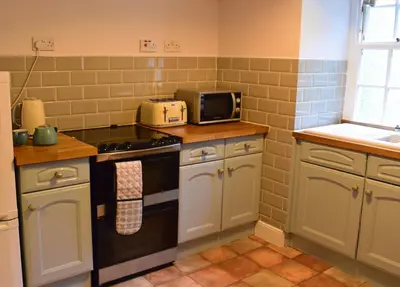 a kitchen with a stove and a microwave at Linnhe Apartment, Kinlochlaich House in Appin