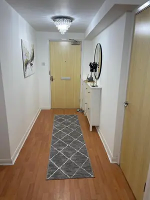 a hallway with a wooden door and a rug at Entire 2 bedroom Beautiful newly furnished flat in Glasgow