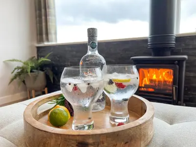 a bottle of wine and two glasses on a table at Ciaran Cottage in Stron-fearnan