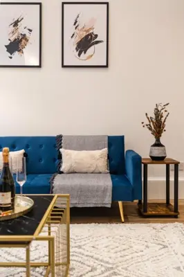 a living room with a blue couch and a table at The City Escape - 5* stay in the heart of Glasgow! in Glasgow