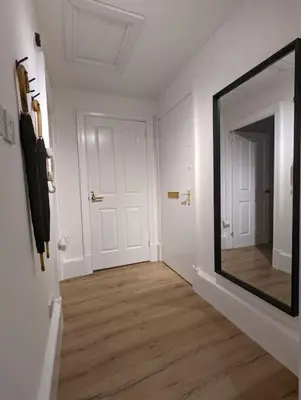 a hallway with a large mirror in a white room at The City Escape - 5* stay in the heart of Glasgow! in Glasgow
