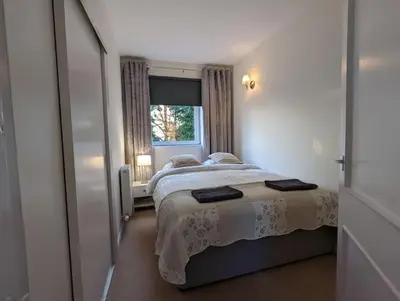a small bedroom with a bed and a window at Two bedroom flat in Bridge of Allan, Stirling in Bridge of Allan