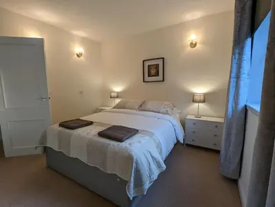 a bedroom with a large bed with two lights on at Two bedroom flat in Bridge of Allan, Stirling in Bridge of Allan