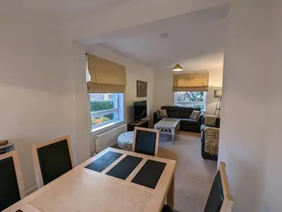 a living room with a table and a couch at Two bedroom flat in Bridge of Allan, Stirling in Bridge of Allan
