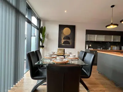 a dining room with a glass table and black chairs at Stunning Apartment at Glasgow Hydro & SECC - Glasg in Glasgow