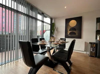 a dining room with a table and chairs and windows at Stunning Apartment at Glasgow Hydro & SECC - Glasg in Glasgow