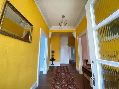 a hallway with yellow walls and a mirror at St John's Flat Spacious Accomodation in Dalry