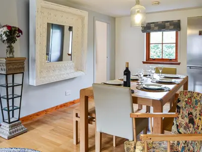 a kitchen and dining room with a table and chairs at Oakwood Cottage - Glencoe in Glencoe