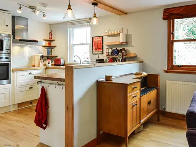 a kitchen with white cabinets and a counter top at Oakwood Cottage - Glencoe in Glencoe