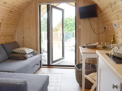 a living room with a couch and a sliding glass door at Pentland Pod - Cottage in Penicuik