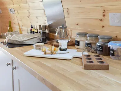 a kitchen counter with a cutting board with food on it at Pentland Pod - Cottage in Penicuik