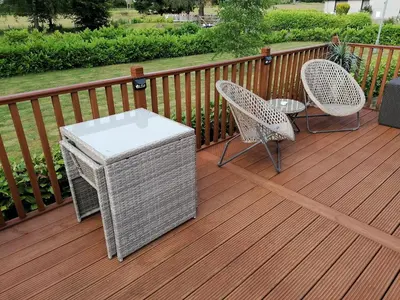two chairs and a table on a wooden deck at Salmon-Leap Lodge in Dollar