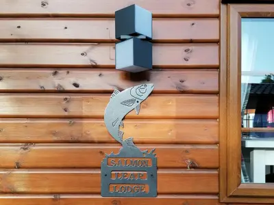 a sign on a house with a fish on it at Salmon-Leap Lodge in Dollar