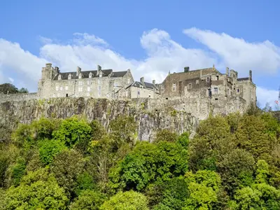 a castle on top of a hill with trees at Salmon-Leap Lodge in Dollar