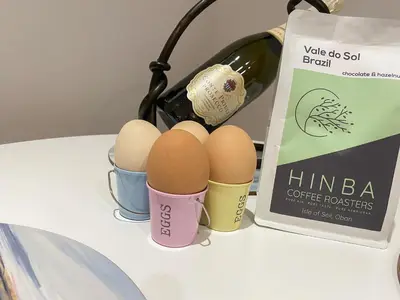 a group of eggs in buckets next to a bottle of wine at Dalnafeidh Beag - Cottage in Portnacroish