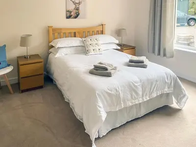 a bedroom with a white bed with towels on it at Dalnafeidh Beag - Cottage in Portnacroish
