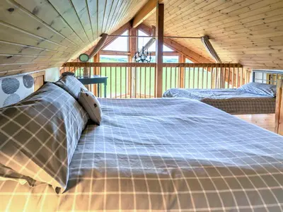 a bedroom with two beds in a wooden house at Tunturi - Cottage in Linlithgow