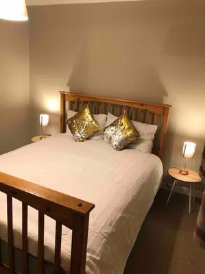 a bedroom with a bed with pillows and two lamps at Cosy Home with Free Parking Near Edinburgh St Andrews M90 & Amazon in Dunfermline