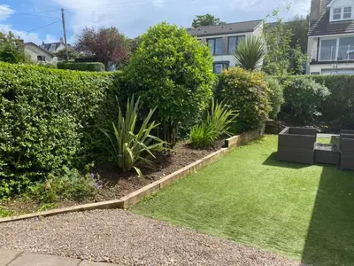 a garden with green grass and bushes at Cosy 3 bedroom home in centre of Brodick in Brodick