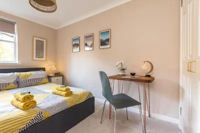 a bedroom with a bed and a table and a chair at Cosy Roseburn Apartment, Edinburgh - 2 Bedrooms, FREE PARKING in Edinburgh