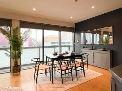 a dining room with a black table and chairs at Lovely 2 Bed Duplex Apartment with Hydro Views in Glasgow