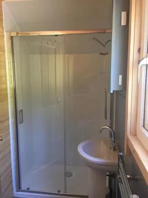 a bathroom with a shower and a sink at The Boathouse pod in Onich