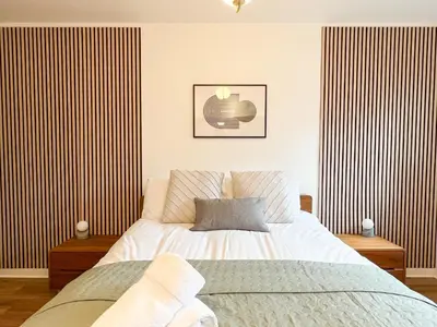 a bedroom with a bed and striped walls at Lovely two bed apartment in Finnieston in Glasgow
