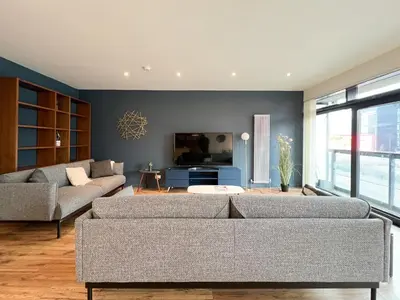 a living room with two couches and a tv at Lovely two bed apartment in Finnieston in Glasgow