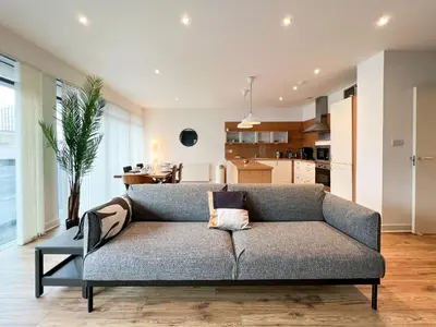 a living room with a couch and a kitchen at Lovely two bed apartment in Finnieston in Glasgow