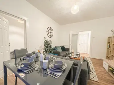 a dining room and living room with a table and chairs at Attractive 3 Bedroom Apartment in Polmadie