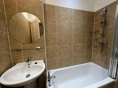 a bathroom with a sink and a tub and a mirror at Bright 3 Bedroom Edinburgh City Apt in Edinburgh