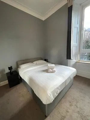 a bedroom with a bed with a teddy bear on it at Bright 3 Bedroom Edinburgh City Apt in Edinburgh