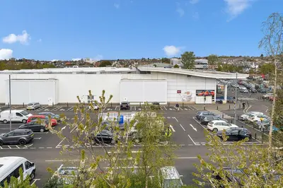 a parking lot with cars parked in front of a building at Modern 1BR flat - free parking + lift in Edinburgh