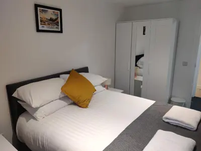 a bedroom with a bed with white and yellow pillows at No 7 Westbay Apartment in Oban