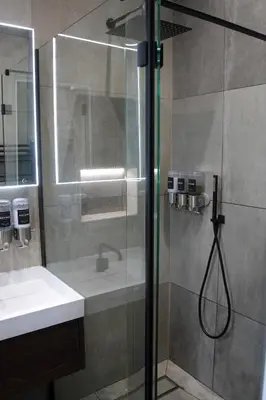 a shower with a glass door next to a sink at Laurieston Inn in Falkirk