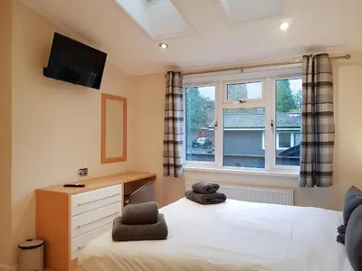 a bedroom with a bed and a desk and a window at Loch Lomond Sanctuary Lodges in Balloch